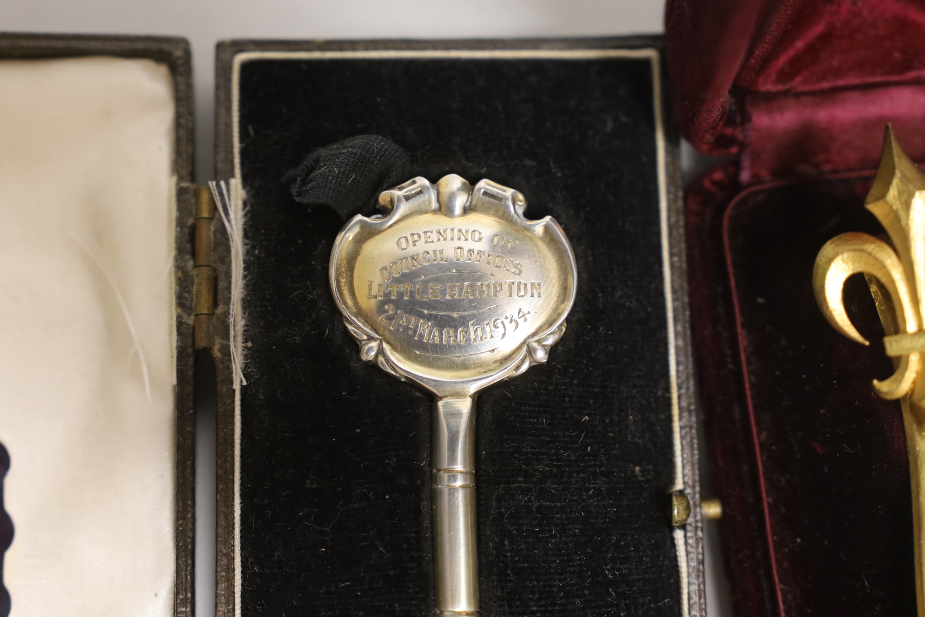 A silver presentation key and gilt metal French tie pin, both cased